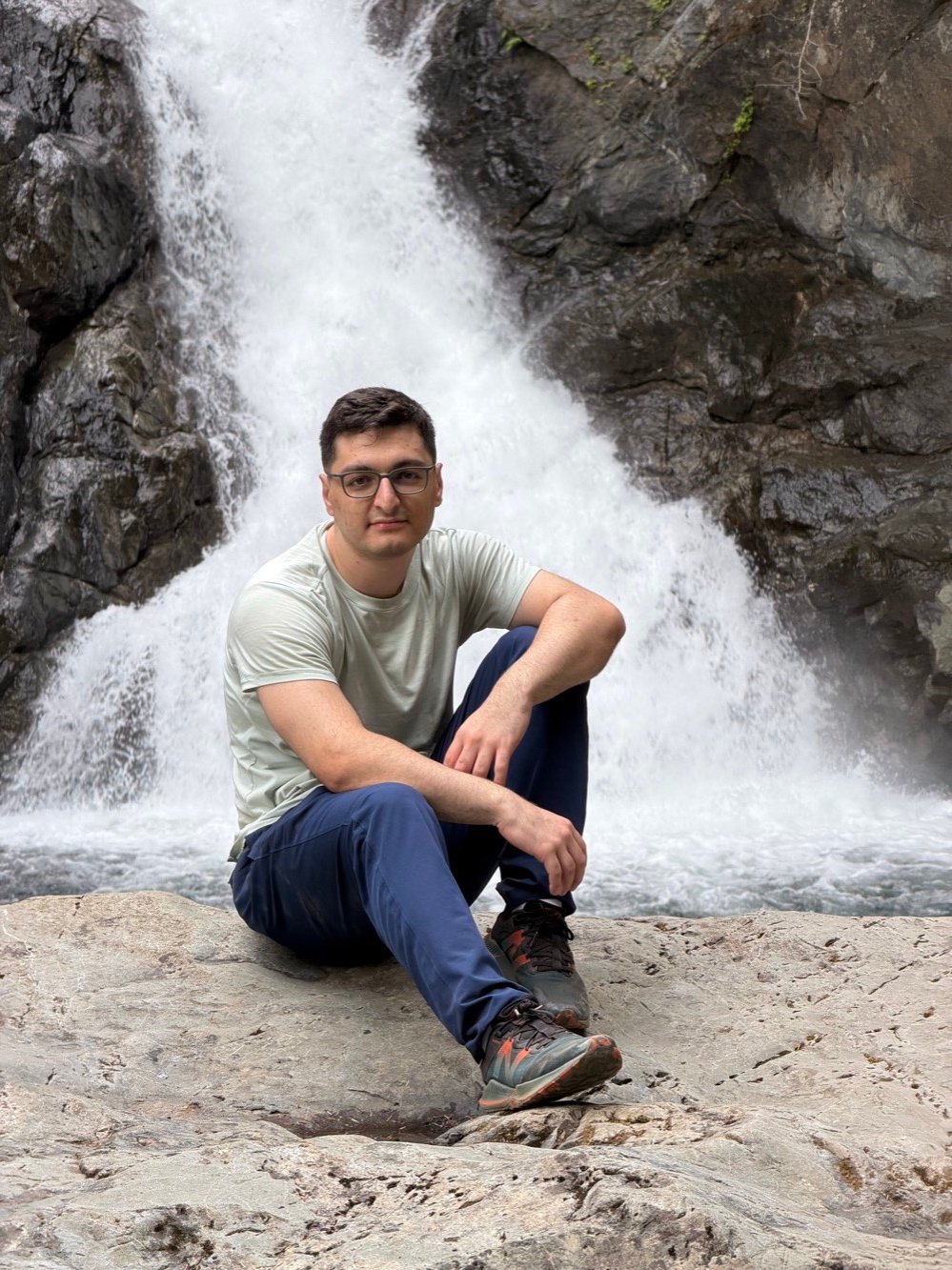 Murad Nabizade sitting in front of a waterfall